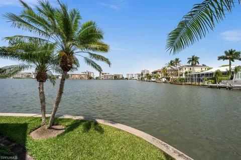an aerial view of residential houses with outdoor space and lake view
