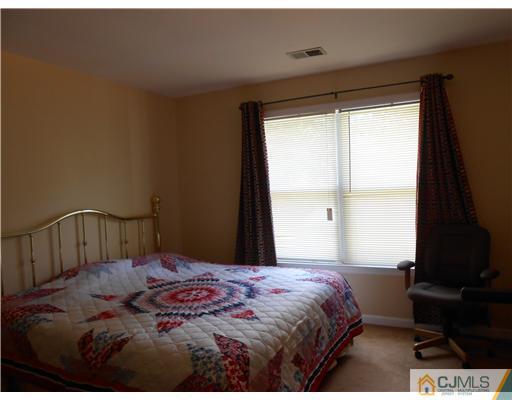 151 Woodbury Road Edison, NJ 08820 - Photo 13 of 15 a bedroom with a bed and a window