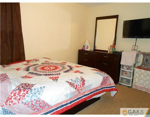 151 Woodbury Road Edison, NJ 08820 - Photo 5 of 15 a bedroom with a bed and a flat screen tv