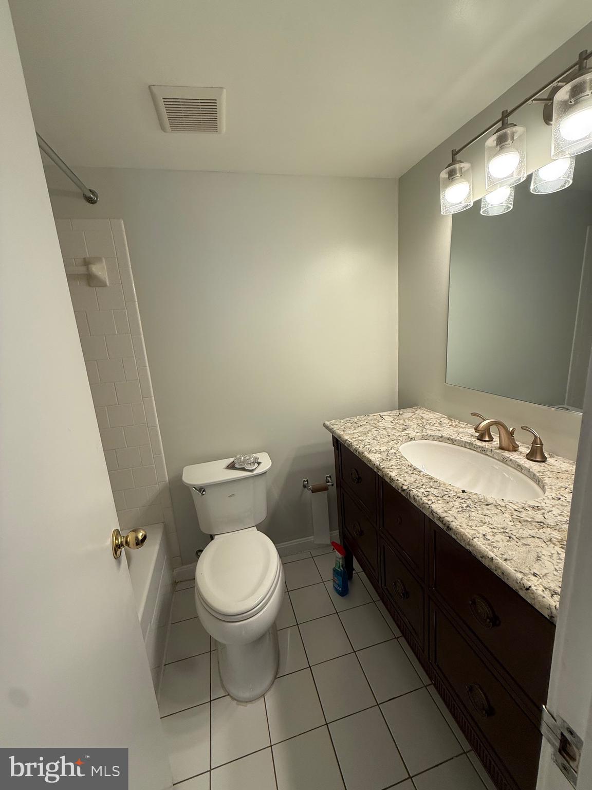 12702 Veirs Mill Road, Unit 51301 Rockville, MD 20853 - Photo 17 of 26 a bathroom with a granite countertop toilet and a sink
