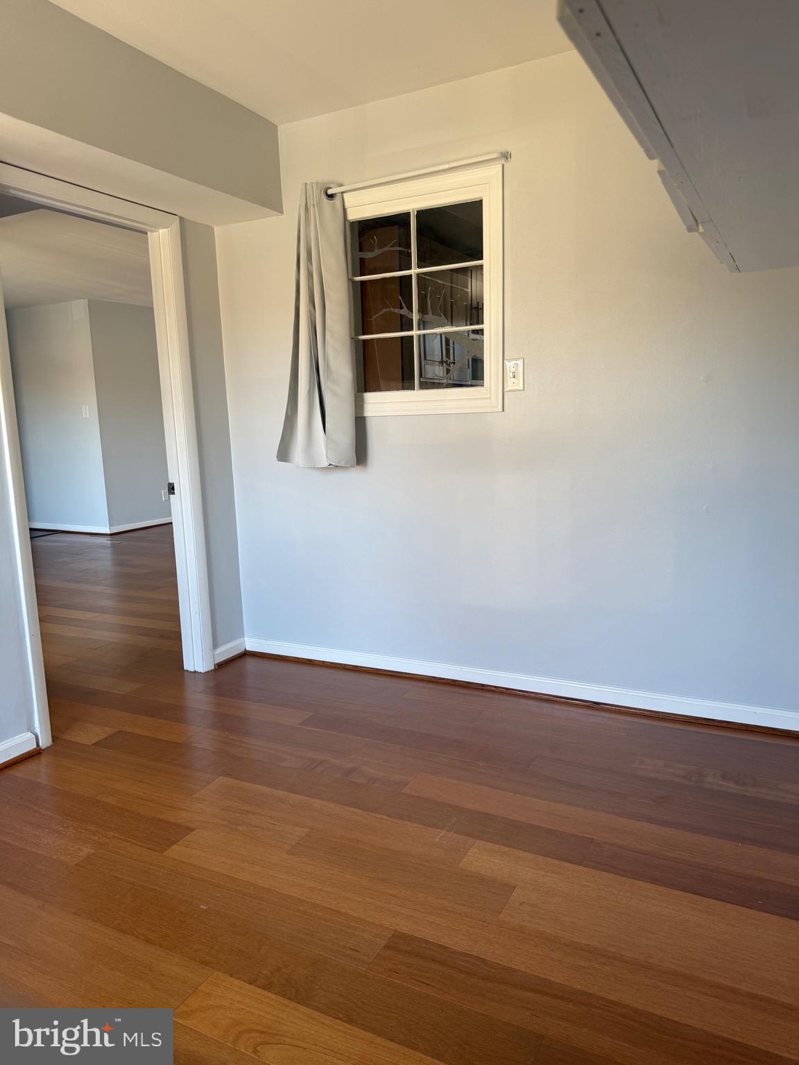 12702 Veirs Mill Road, Unit 51301 Rockville, MD 20853 - Photo 25 of 26 a view of an empty room with wooden floor and a window