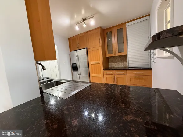 a kitchen with granite countertop cabinets and refrigerator