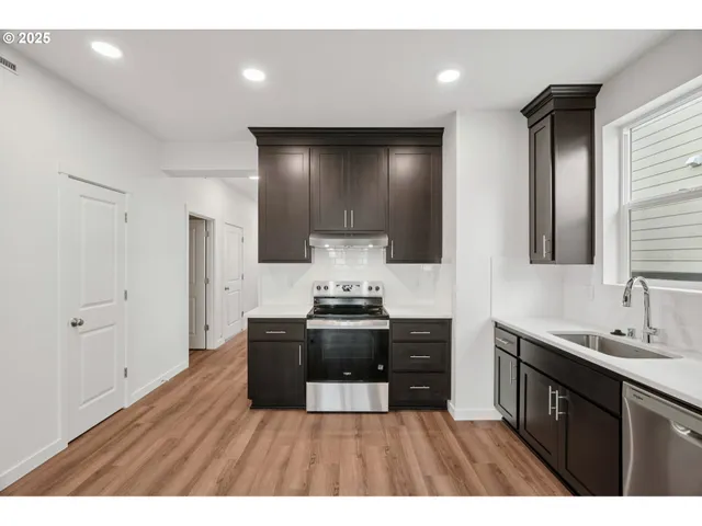 a kitchen with stainless steel appliances granite countertop a stove a sink and a refrigerator