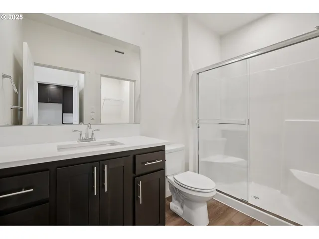 a bathroom with a granite countertop sink toilet a mirror and shower
