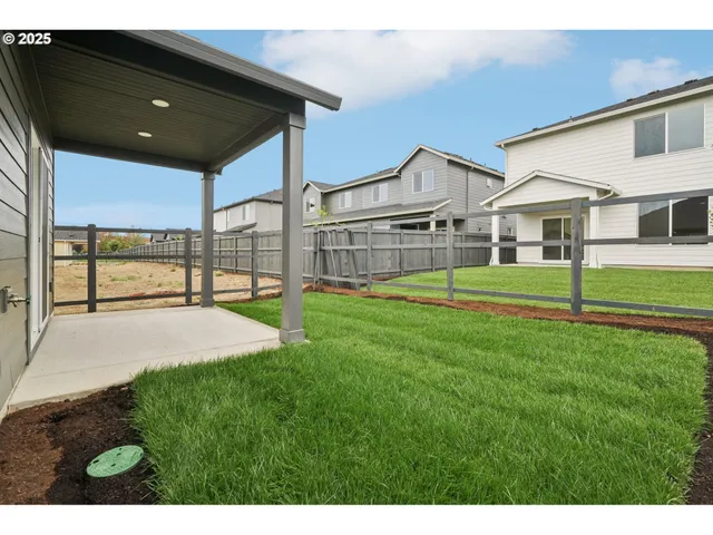 a view of house with a big yard and large trees