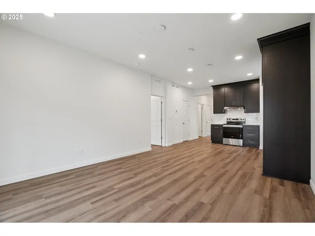 a view of kitchen with refrigerator and wooden floor