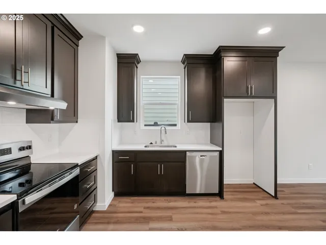 a kitchen with a sink stainless steel appliances and cabinets