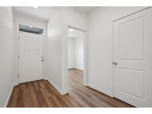 a view of an empty room with wooden floor