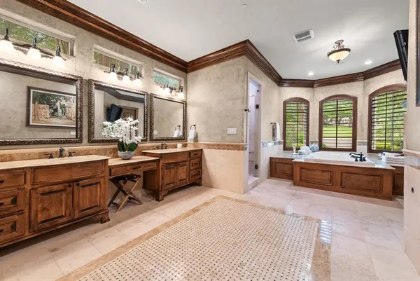a spacious bathroom with a double vanity sink large mirror and a bathtub