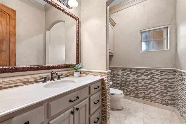 a bathroom with a granite countertop sink mirror and a toilet