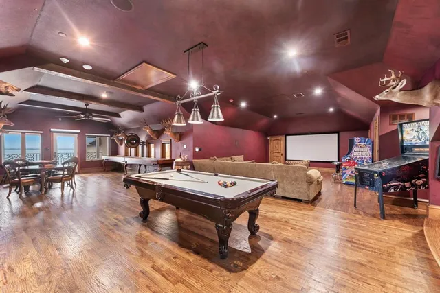 a room with furniture pool table flat screen tv and a clock