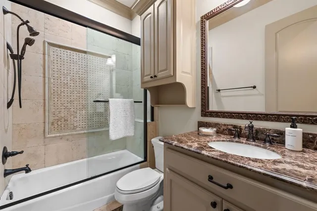 a bathroom with a granite countertop sink toilet and shower
