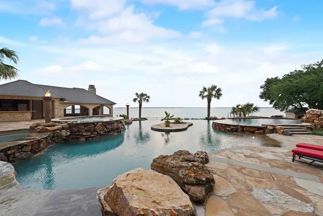 a view of ocean with boats and trees in the background