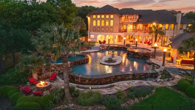 an aerial view of a house with a yard and lake view