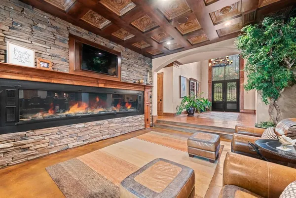 a living room with furniture a flat screen tv and a fireplace