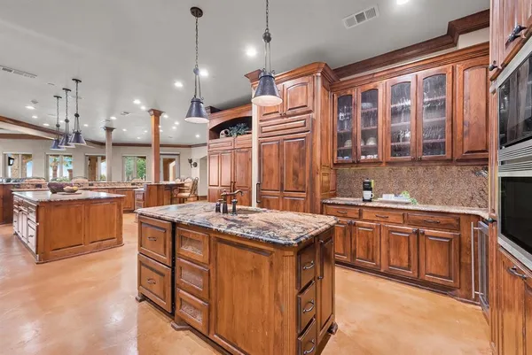 a kitchen that has a lot of cabinets in it and stainless steel appliances