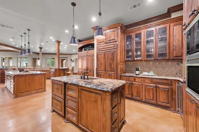 a kitchen that has a lot of cabinets in it and stainless steel appliances