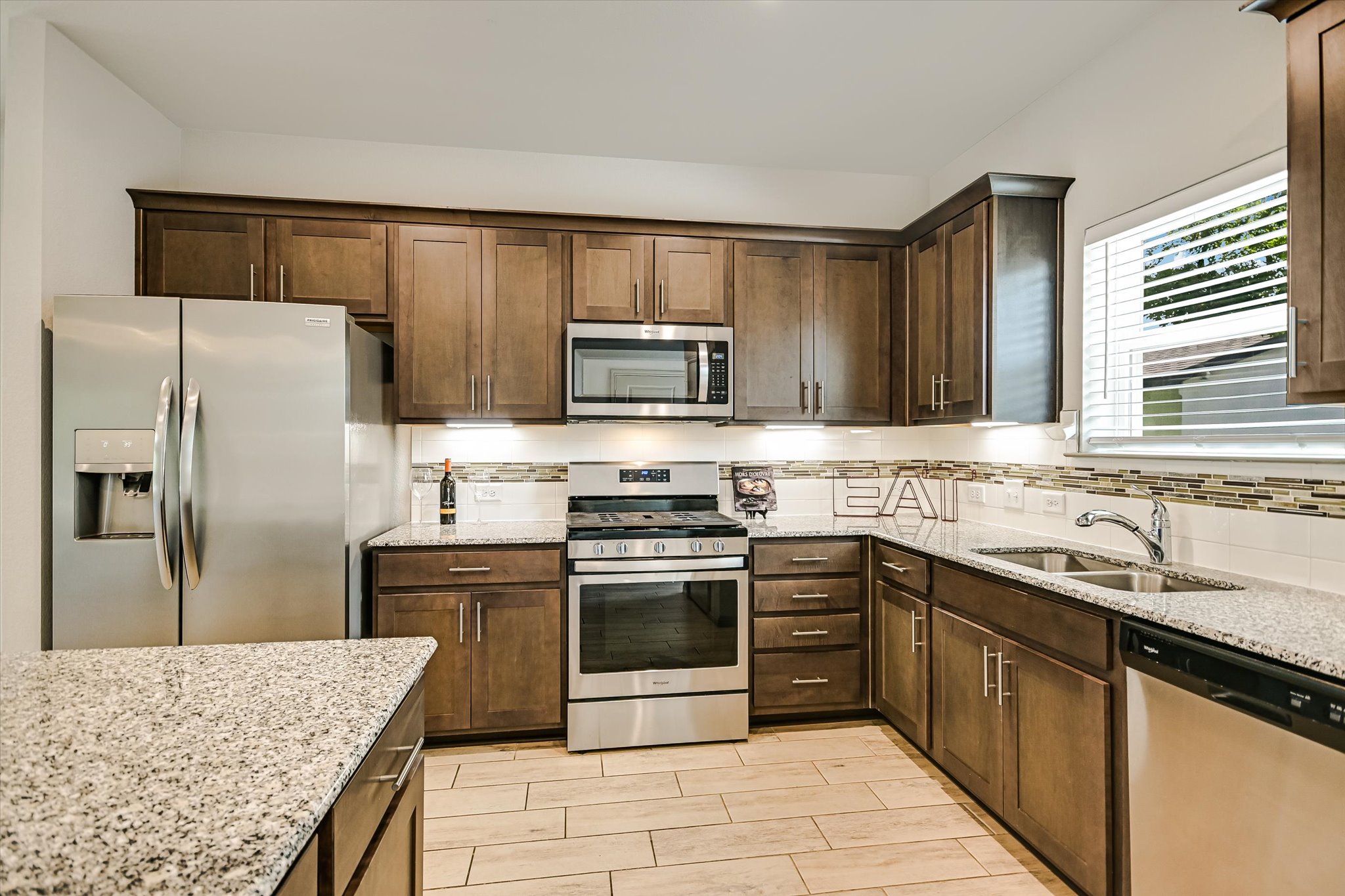 5613 Charles Merle Dr. Austin, TX 78747 - Photo 8 of 34 a kitchen with stainless steel appliances granite countertop a sink stove microwave and refrigerator