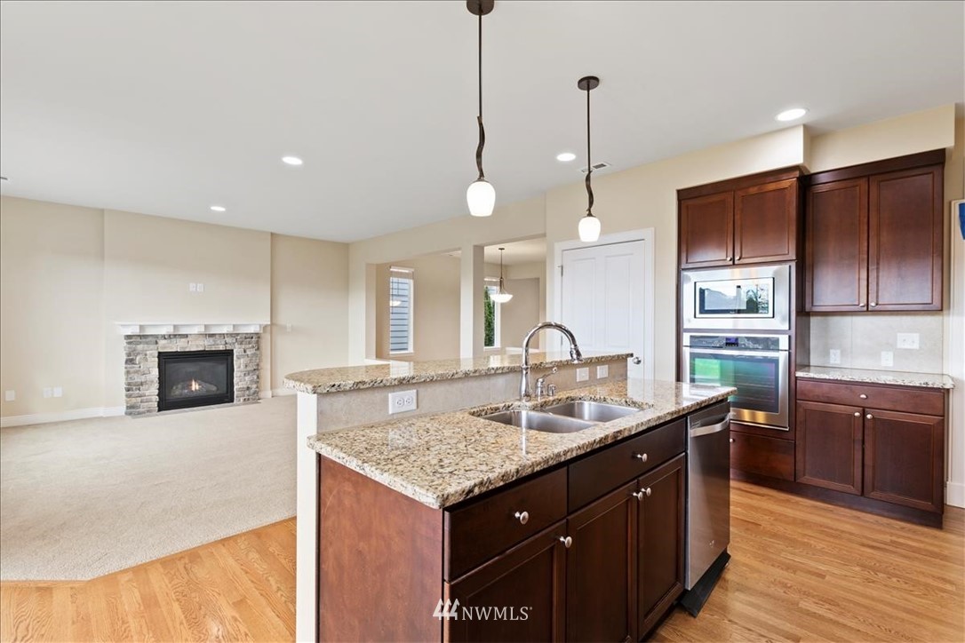 23004 44th Drive Southeast Bothell, WA 98021 - Photo 8 of 29 a kitchen with kitchen island granite countertop a sink cabinets and stainless steel appliances