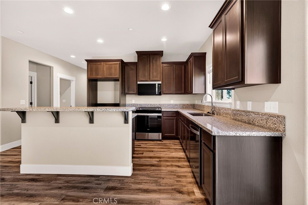 7083 Pentz Road Paradise, CA 95969 - Photo 11 of 46 a large kitchen with stainless steel appliances granite countertop a stove a sink and a microwave