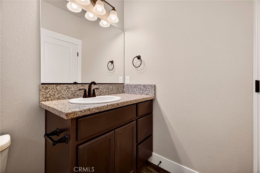 7083 Pentz Road Paradise, CA 95969 - Photo 27 of 46 a bathroom with a granite countertop sink a toilet and a mirror