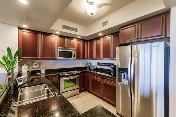 a kitchen with granite countertop a refrigerator stove and microwave