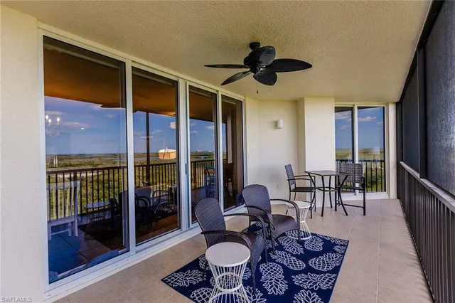 a dining room with furniture and a floor to ceiling window