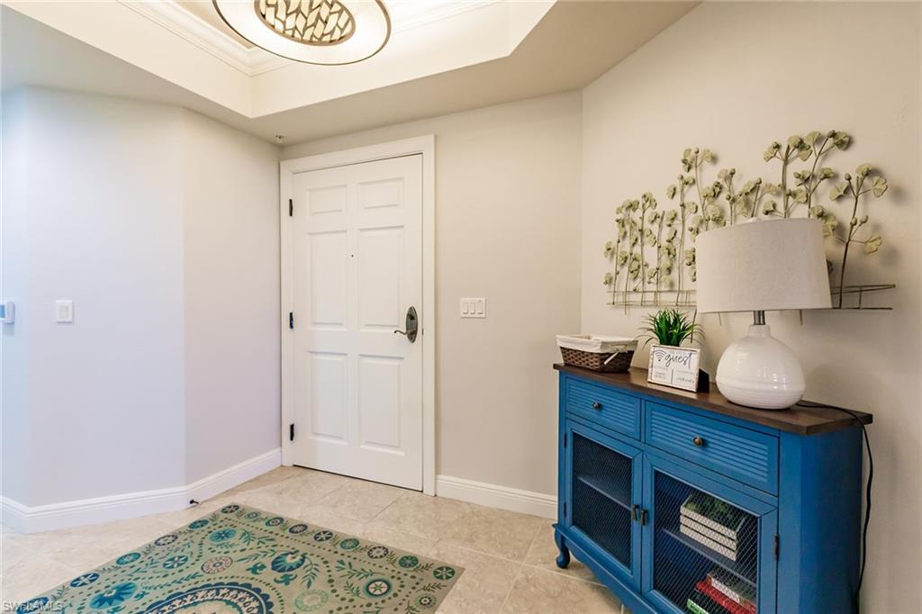 1065 Borghese Lane, Unit 1003 Naples, FL 34114 - Photo 4 of 43 a room with a dresser and a wooden floor