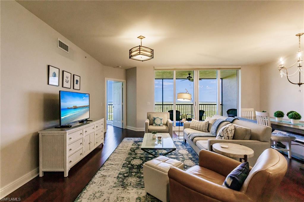 1065 Borghese Lane, Unit 1003 Naples, FL 34114 - Photo 6 of 43 a living room with furniture and a flat screen tv