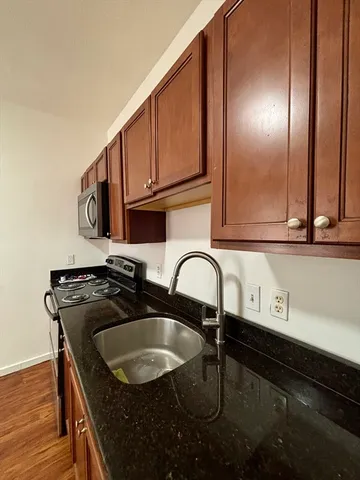a kitchen with a sink a stove and cabinets