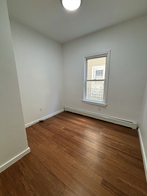 39 Shawmut Street, Unit 1 Chelsea, MA 02150 - Photo 5 of 13 an empty room with wooden floor and windows