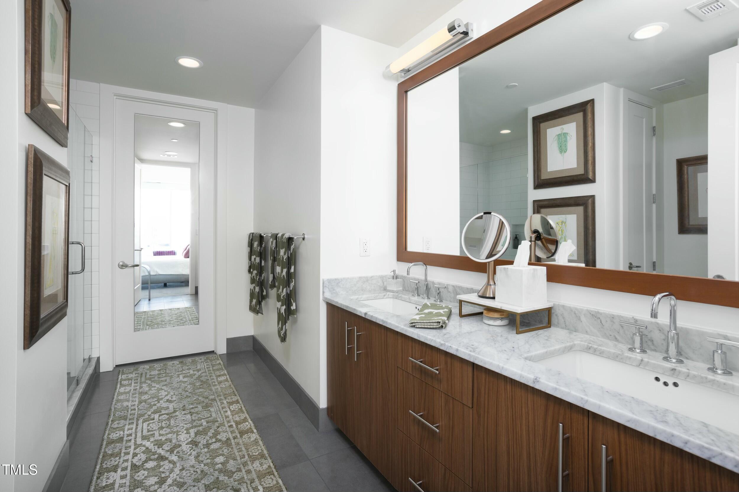 110 Corcoran Street, Unit 2502 Durham, NC 27701 - Photo 32 of 87 a bathroom with a double vanity sink and a mirror