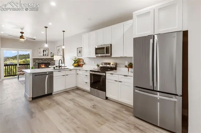 a kitchen with white cabinets and stainless steel appliances