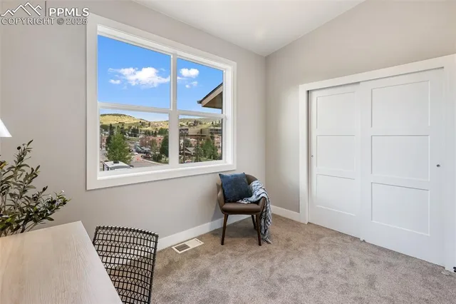 a view of an empty room with painting on wall and a potted plant