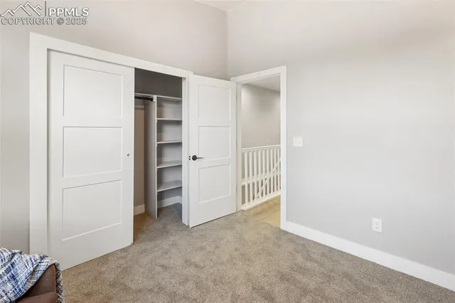 a view of a hallway with white walls and a window