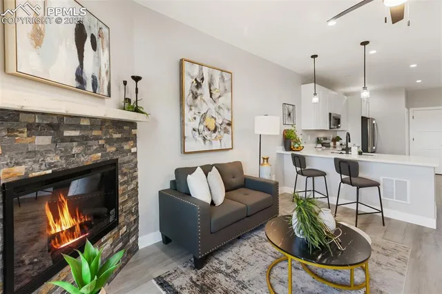a living room with furniture a fireplace and a floor to ceiling window