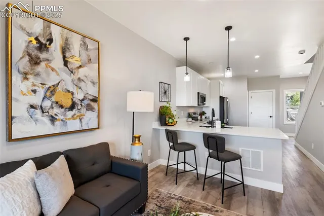a living room with furniture a fireplace and a large window