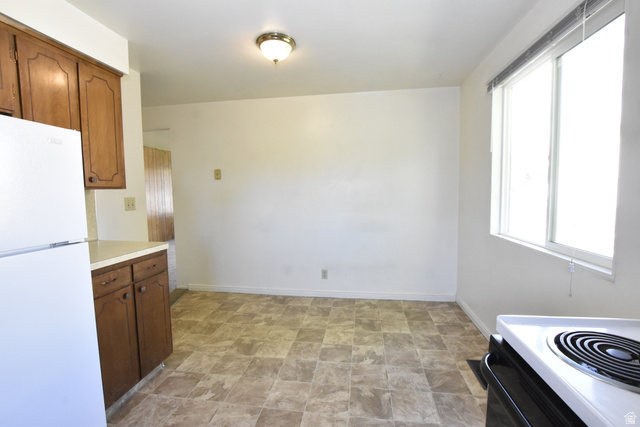 290 West 600 North Logan, UT 84321 - Photo 38 of 45 Kitchen space featuring a window, patterned floor tile, white walls, and a ceiling-mounted light fixture