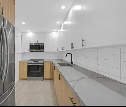 a kitchen with stainless steel appliances granite countertop a sink and a stove
