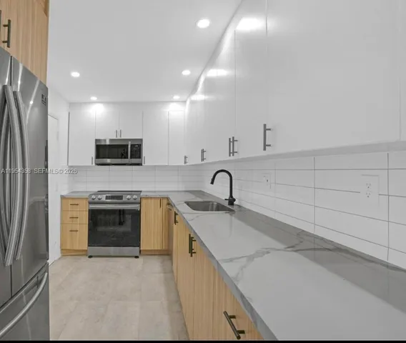 a kitchen with stainless steel appliances granite countertop a sink and a stove