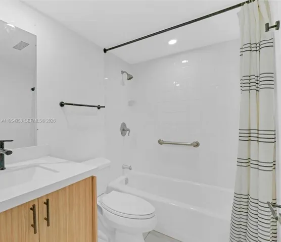 a bathroom with a bathtub shower sink vanity and toilet