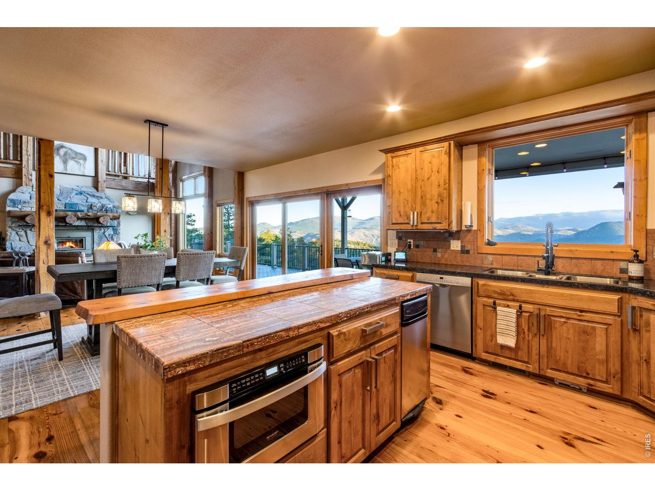 5433 North Rim Road Livermore, CO 80536 - Photo 21 of 50 granite tile countertops, knotty alder cabinets, crown molding, hardware, Lazy Susan, undermount lighting, stainless steel appliances, double ovens, 6-burner gas range, hood system, pot rack and trash compactor