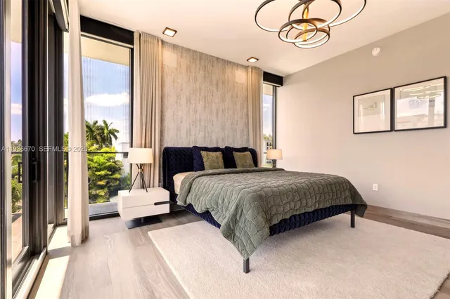 a bedroom with a large bed and a chandelier