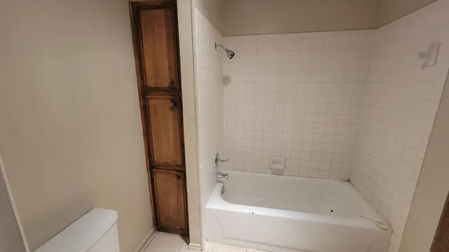 an empty room with windows and ceiling fan