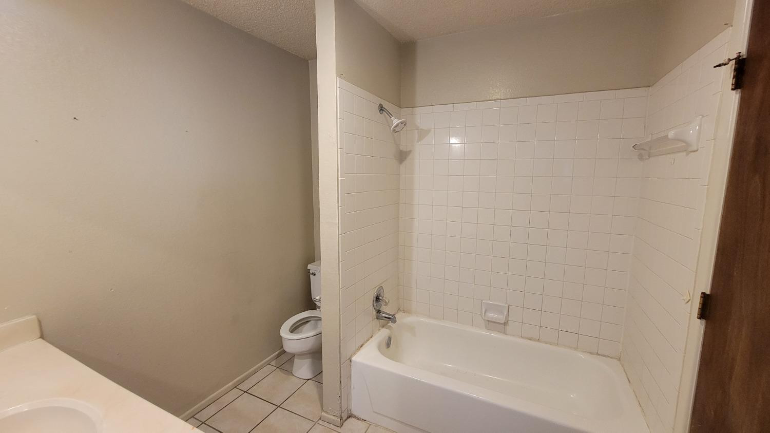1107 80th Street, Unit B Lubbock, TX 79423 - Photo 10 of 12 a bathroom with a bathtub and a toilet