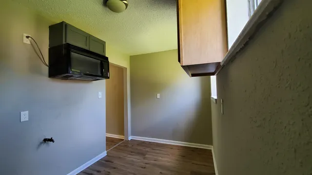 a view of a livingroom with wooden floor and windows
