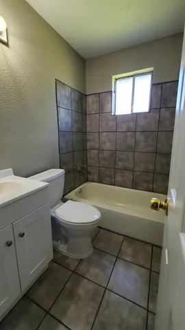 a bathroom with a toilet a sink a mirror and bathtub