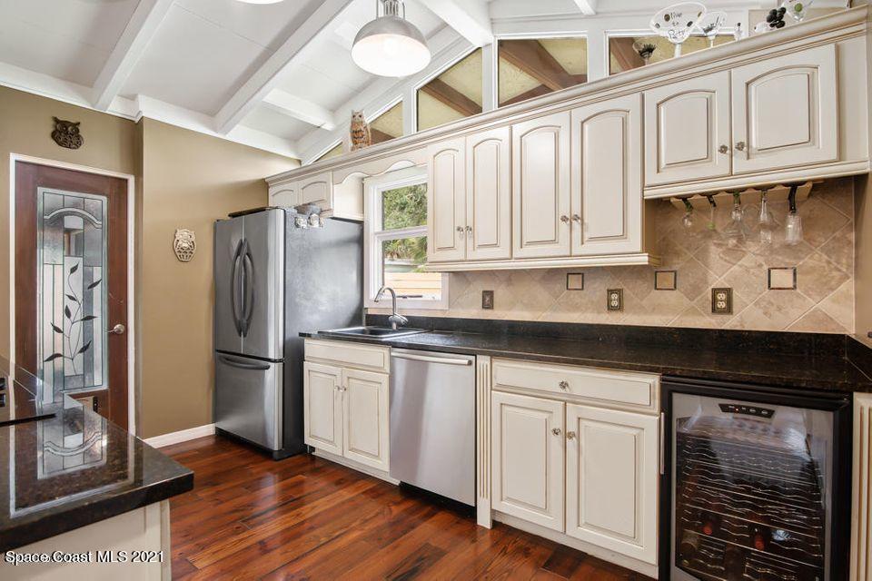 907 Santa Cruz Road Cocoa Beach, FL 32931 - Photo 3 of 30 a kitchen with stainless steel appliances granite countertop a sink and cabinets with wooden floor