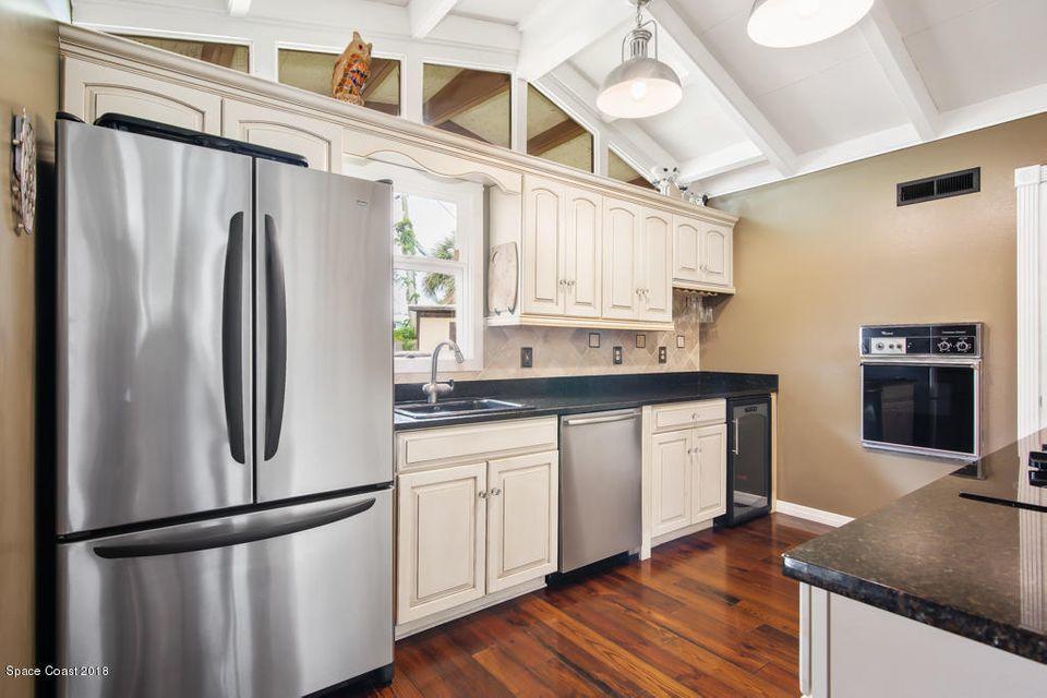 907 Santa Cruz Road Cocoa Beach, FL 32931 - Photo 4 of 30 a kitchen with stainless steel appliances granite countertop a refrigerator a stove and a sink with wooden floor