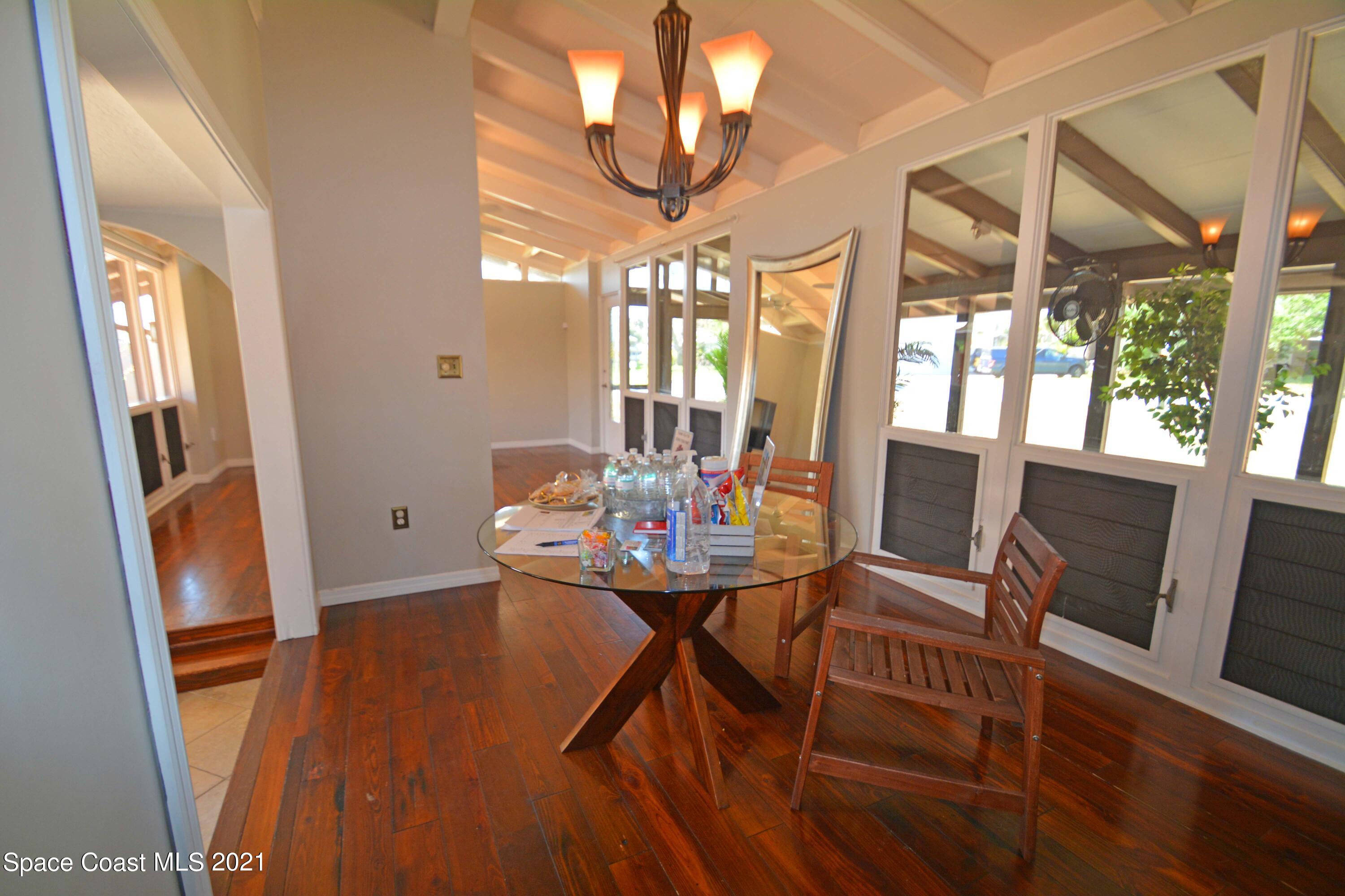 907 Santa Cruz Road Cocoa Beach, FL 32931 - Photo 6 of 30 a view of a dining room with furniture wooden floor and chandelier